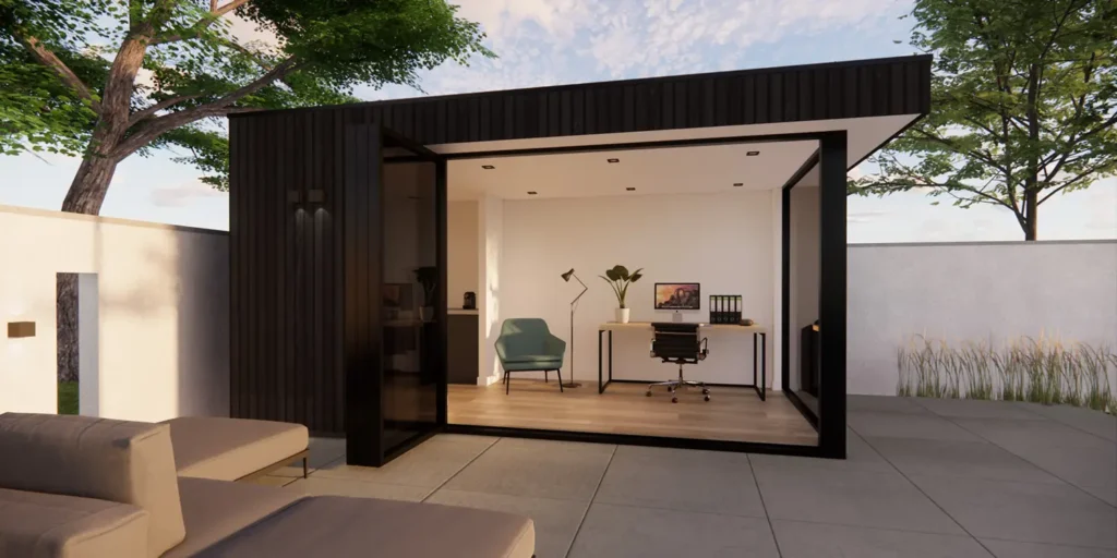 Een compact tuinkantoor met ruime werkplek en relaxhoek. Achter een scheidingsmuur is een keukenblok te zien.